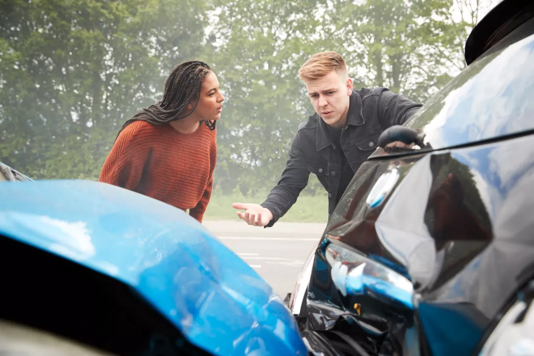 two angry motorists arguing over responsibility for a crash