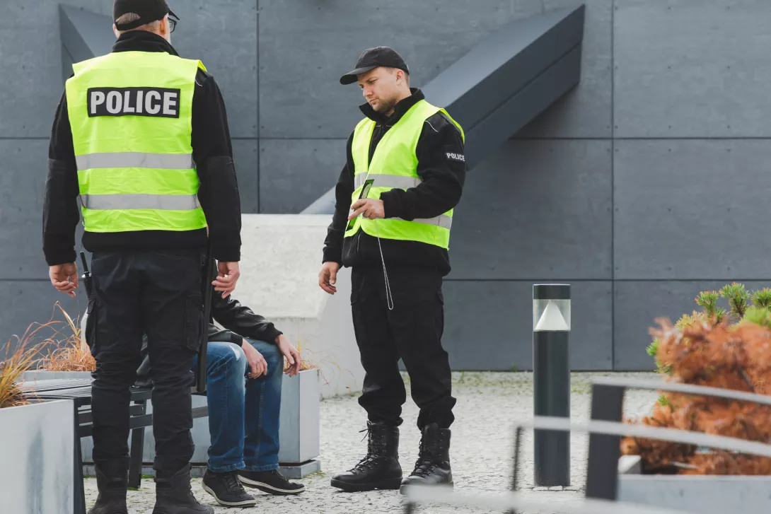 two police officers talking to someone on the street