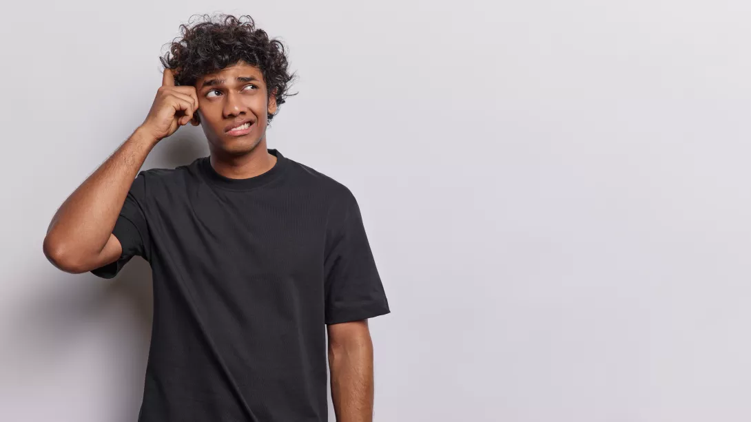 waist-up-shot-of-confused-curly-haired-young-hindu