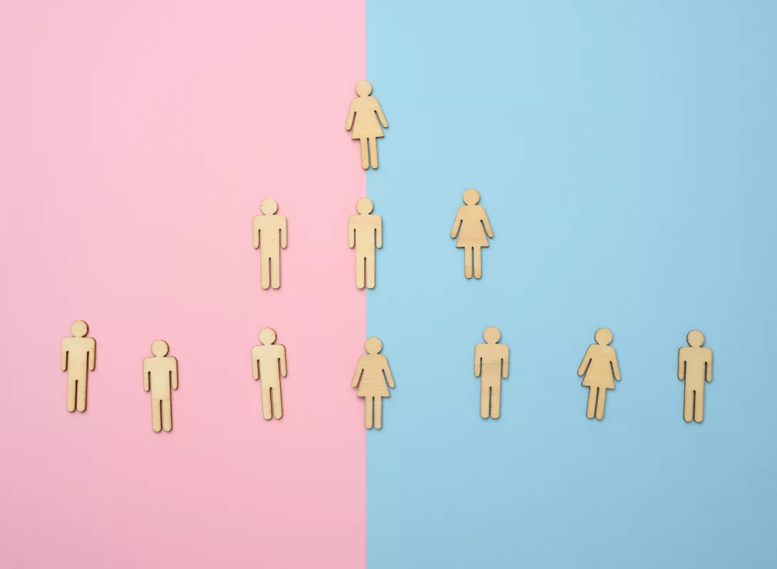wooden figures on a pink and blue background