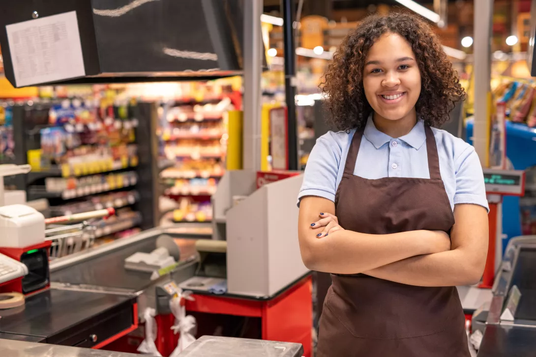 young-smiling-shop-assistant-or-cashier-in-workwear