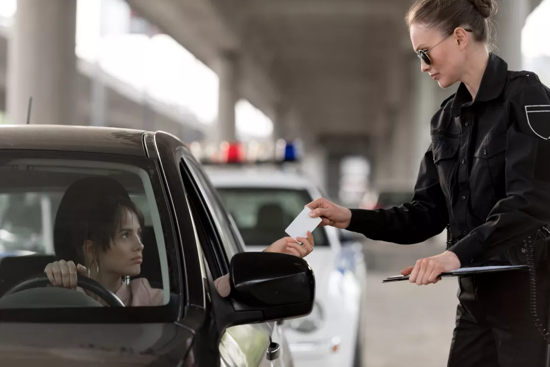 young-woman-in-car-giving-driver-license-to-police