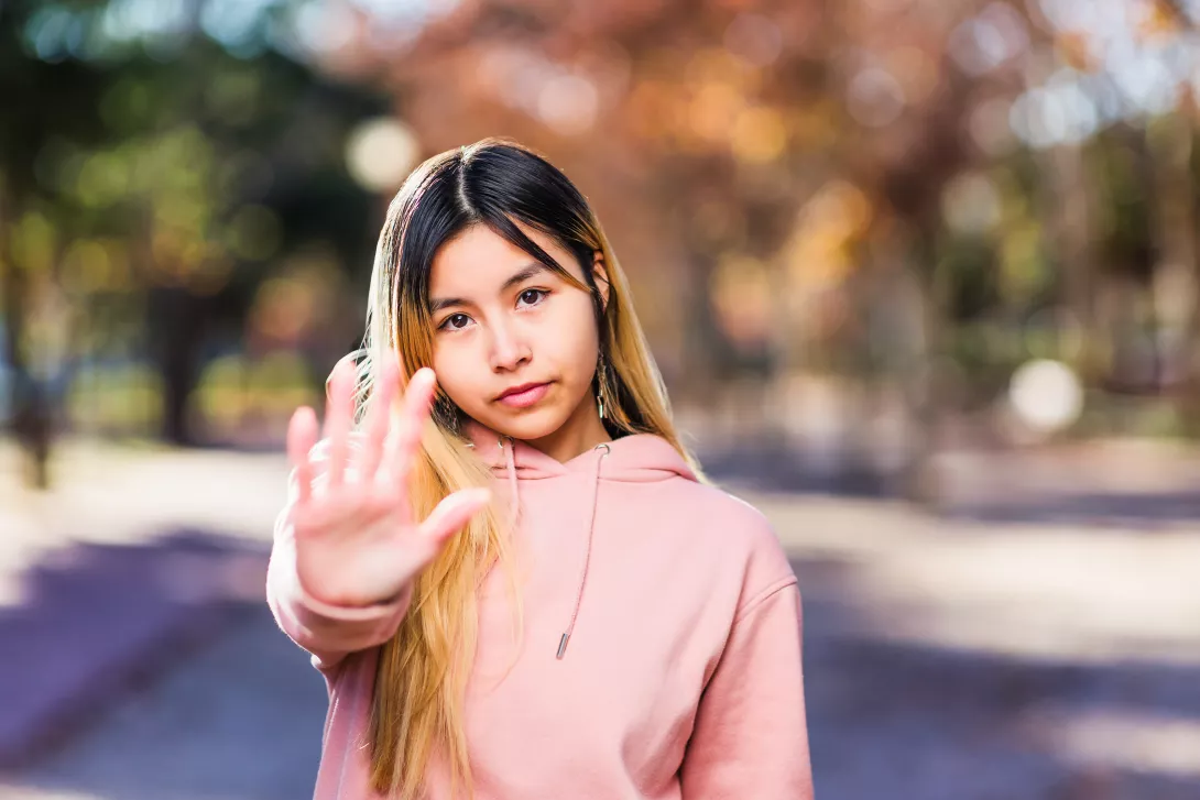 girl holding her hand out to say "stop"